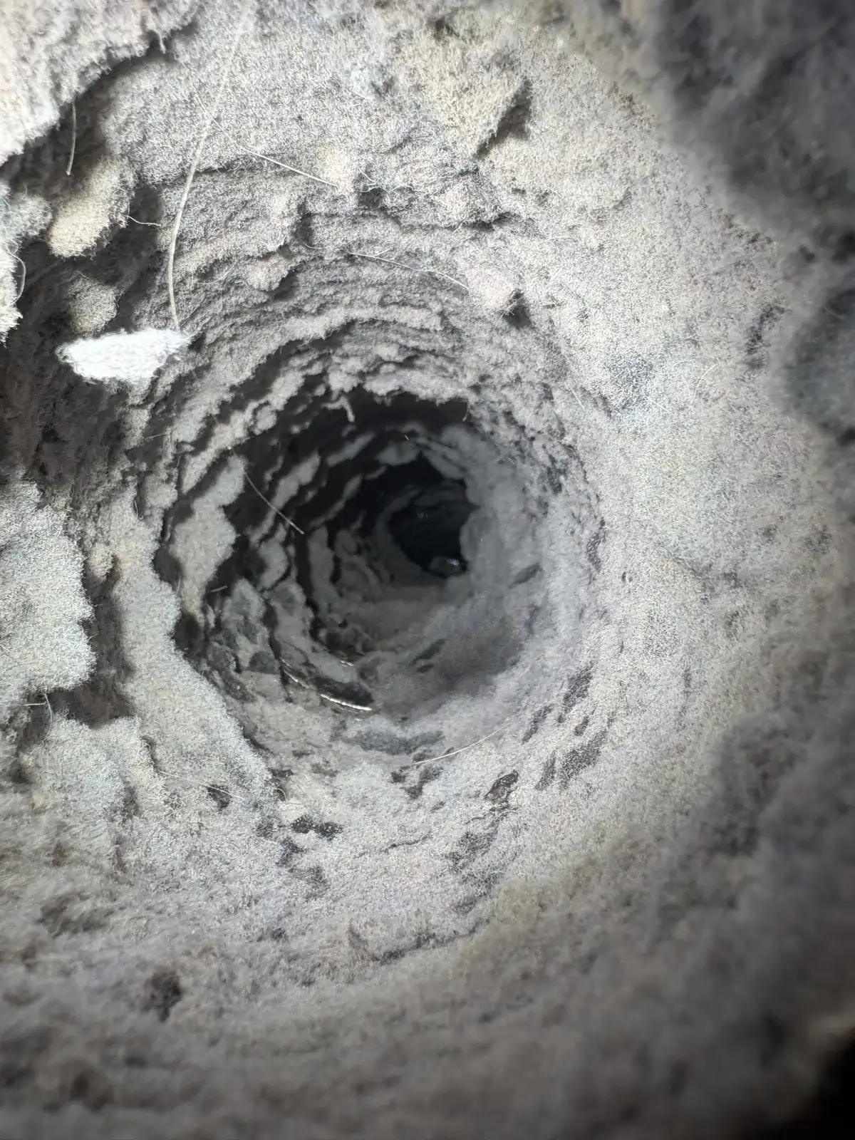 Camera-scope view down the inside of a lint-coated dryer duct