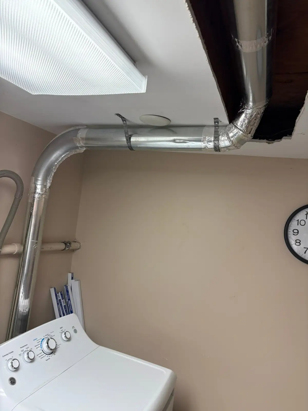 A newly installed rigid metal dryer duct in a Madison, NJ laundry room