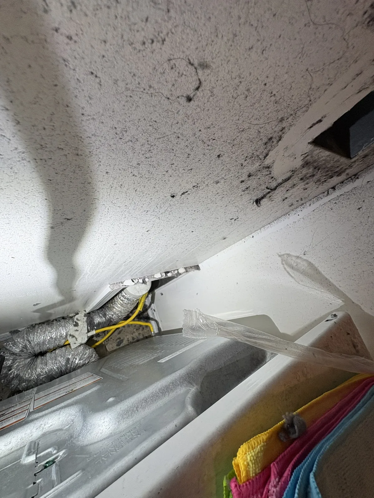Crushed flexible foil dryer ducts packed into the gap behind a dryer