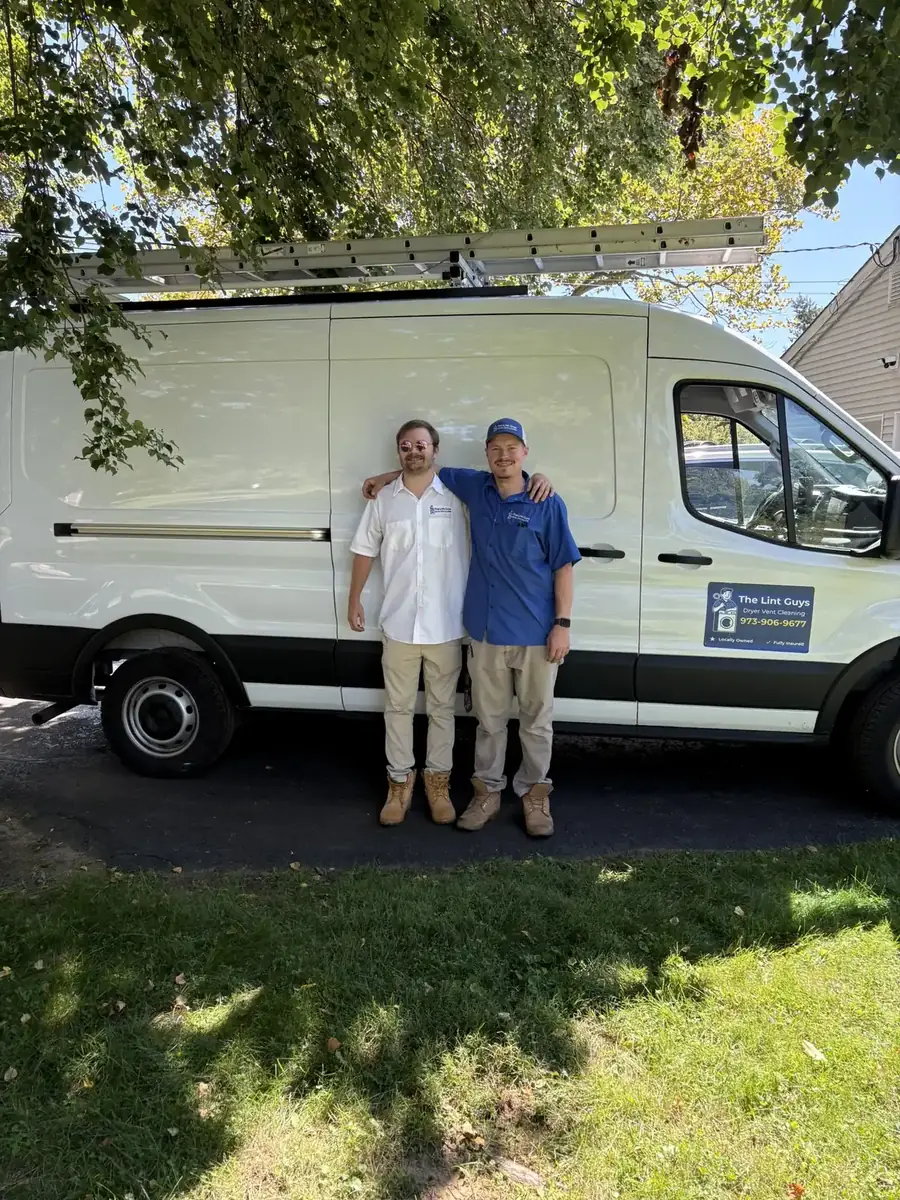 Two Lint Guys technicians standing in front of the service van